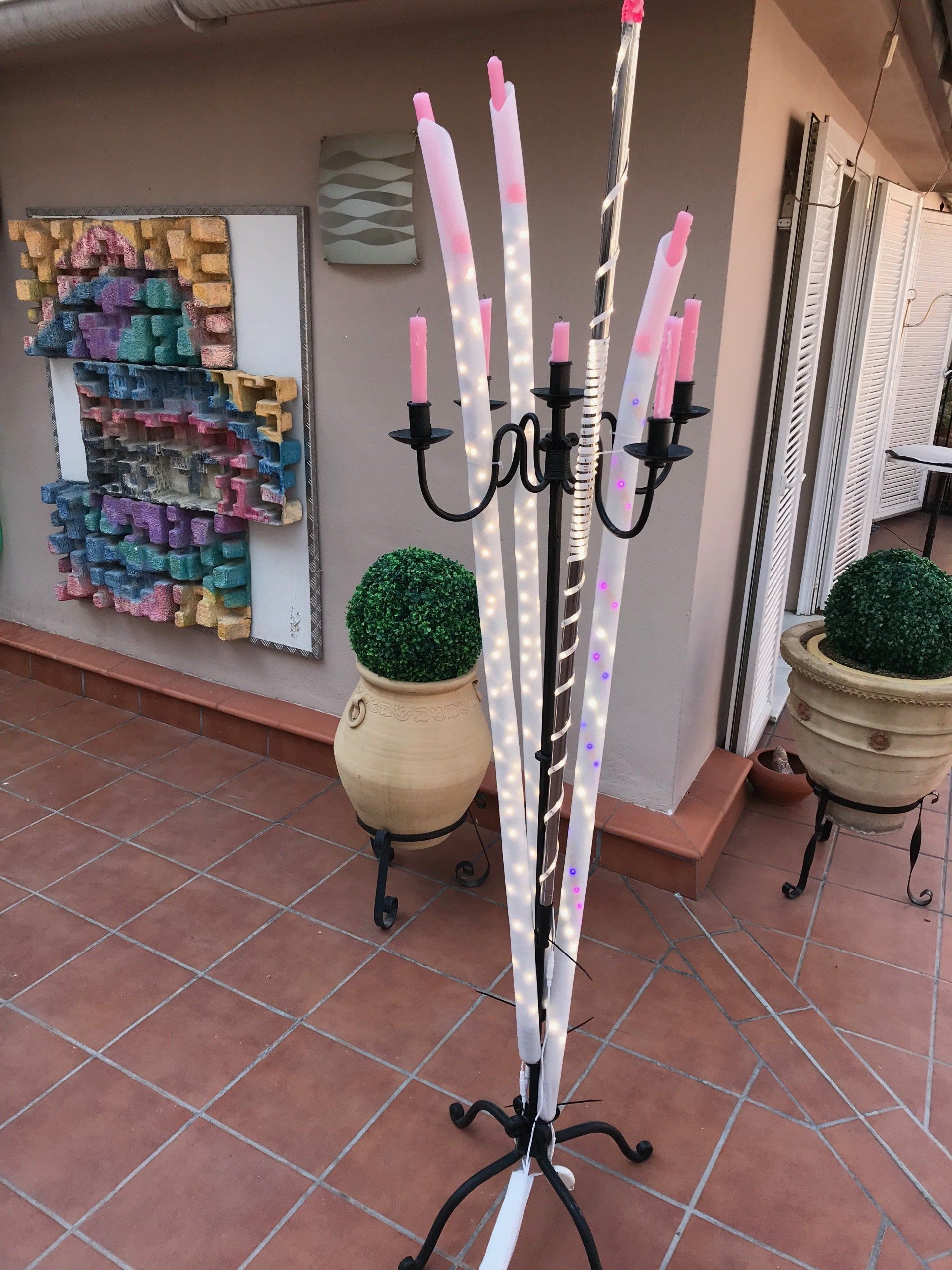 Ein Kandelaber mit einem Haufen rosa Kerzen darauf