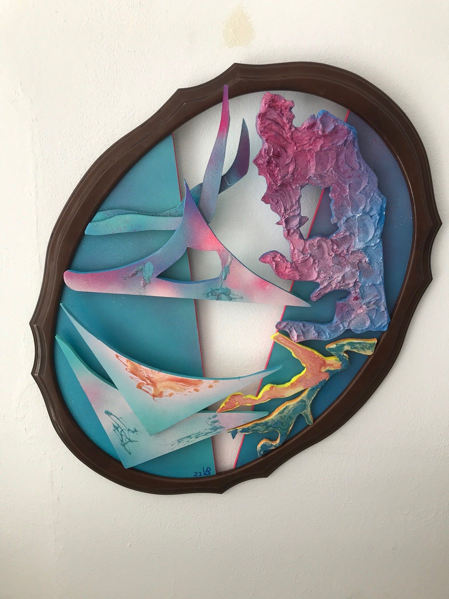 Ein Gemälde in einem braunen Rahmen hängt an einer Wand