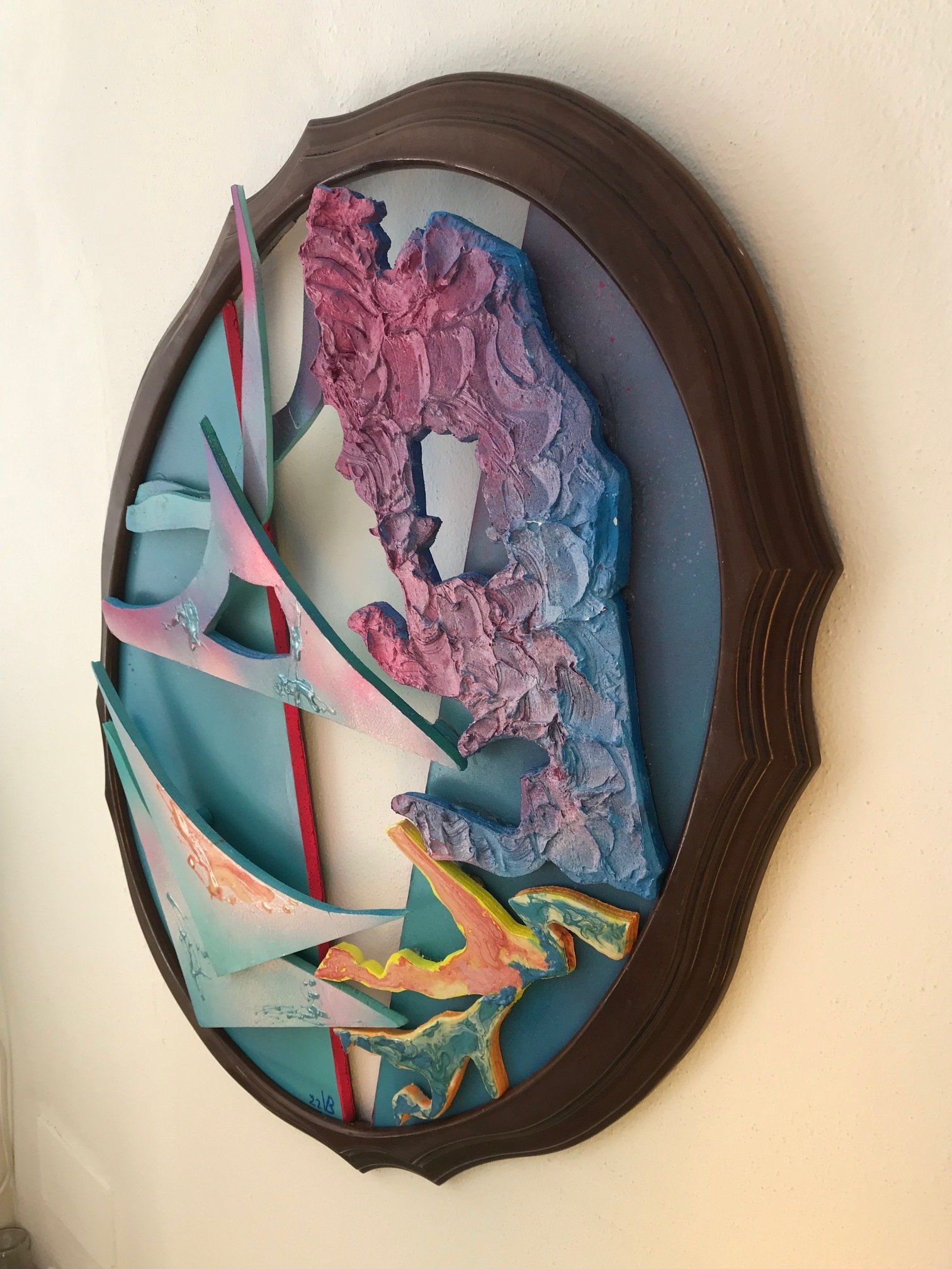 Ein buntes Gemälde hängt an einer weißen Wand