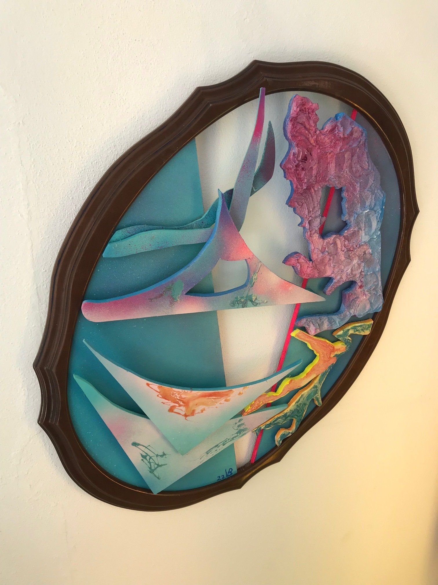 Ein Gemälde in einem Holzrahmen an einer weißen Wand