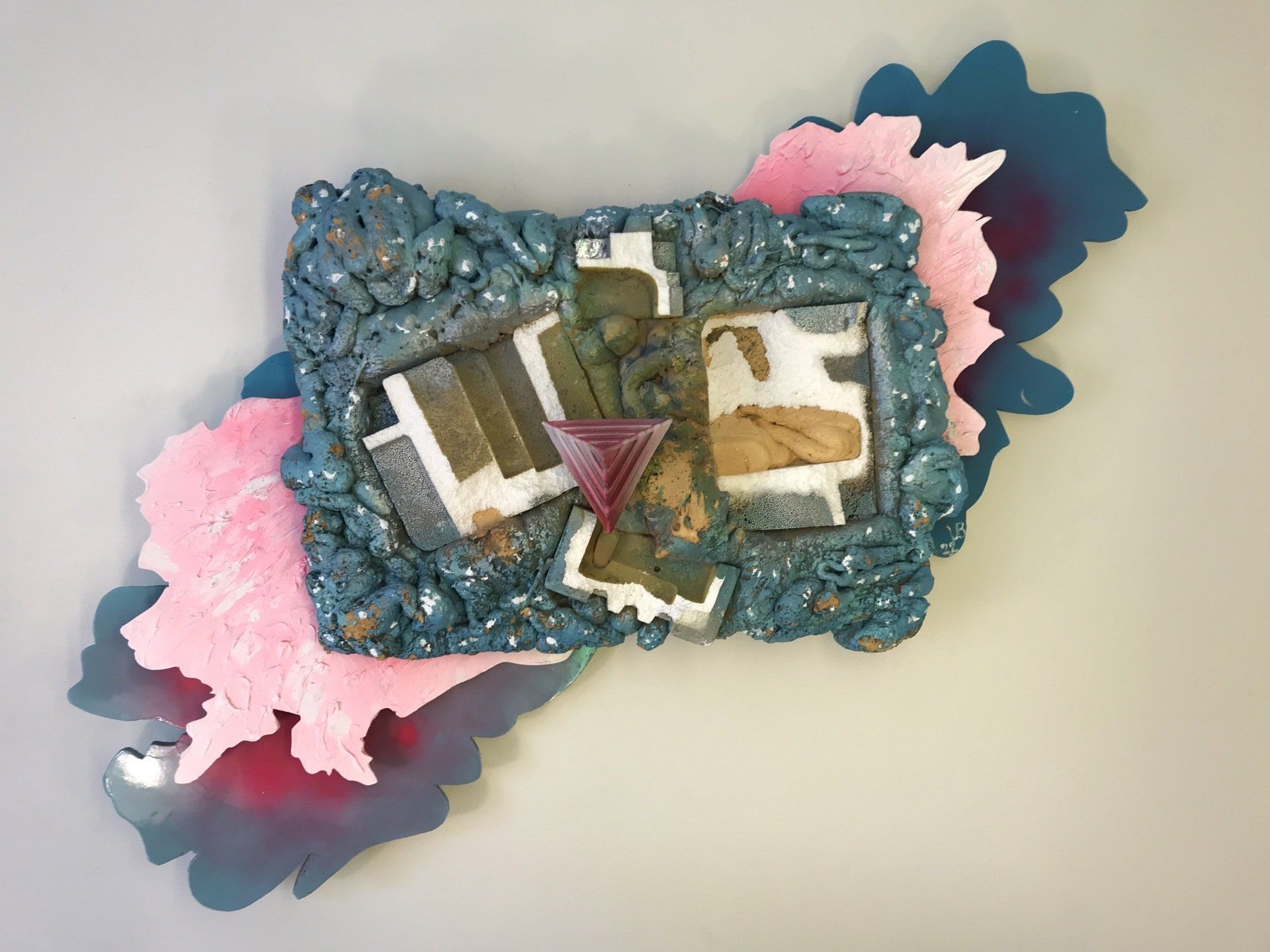 Eine blau-rosa Skulptur mit dem Buchstaben T darauf