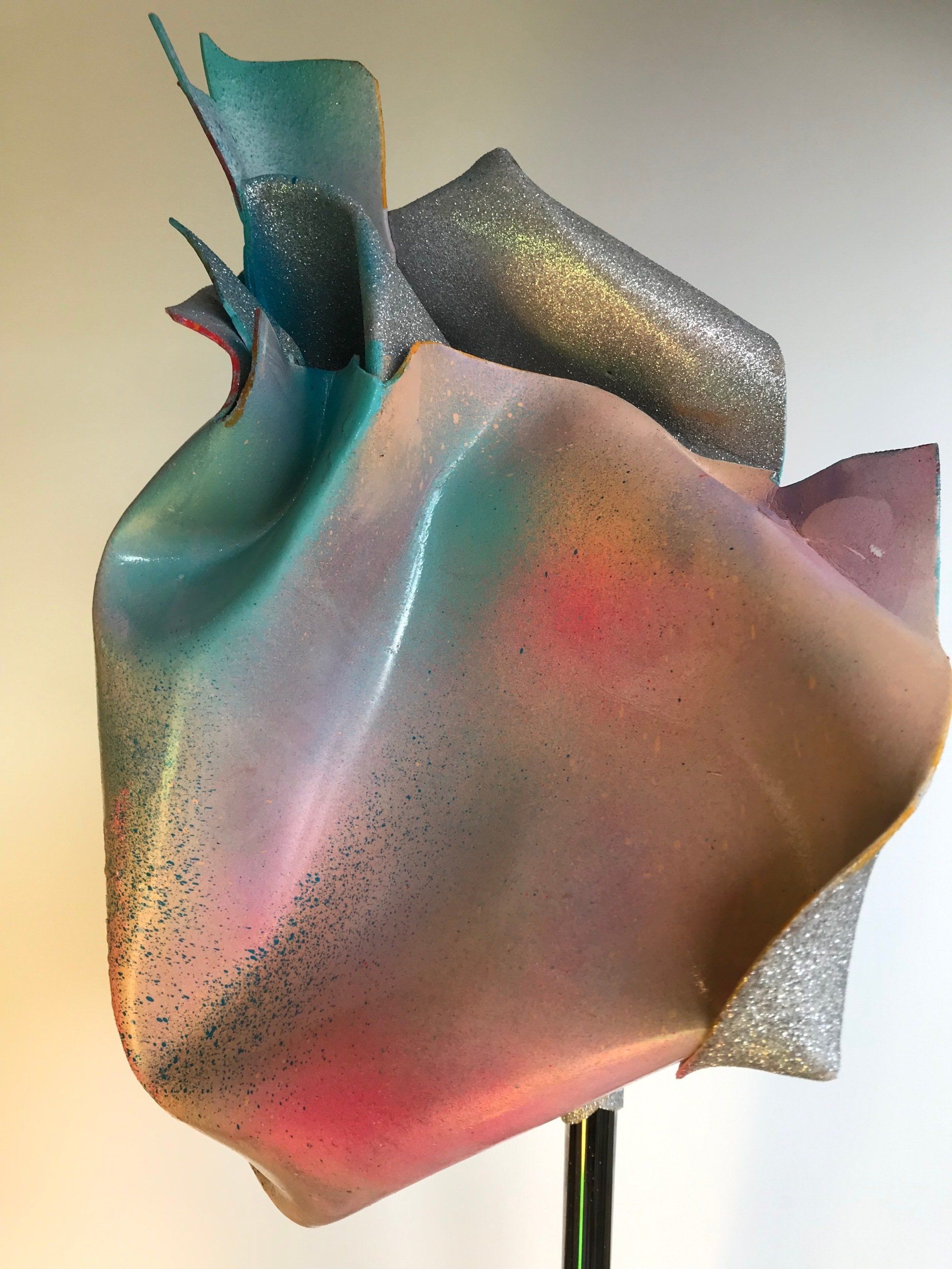 Eine Skulptur eines Herzens mit einem Regenbogen aus Farben