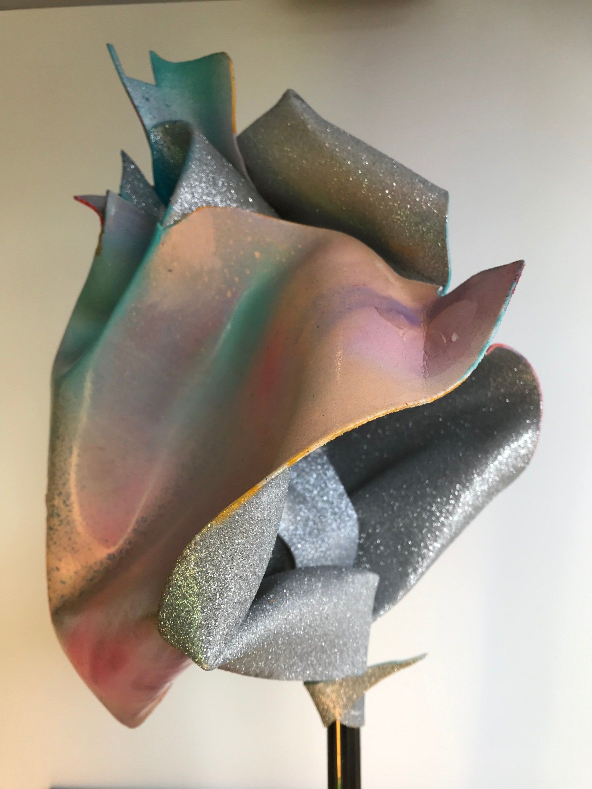Eine Skulptur einer Blume mit einem Regenbogen aus Farben