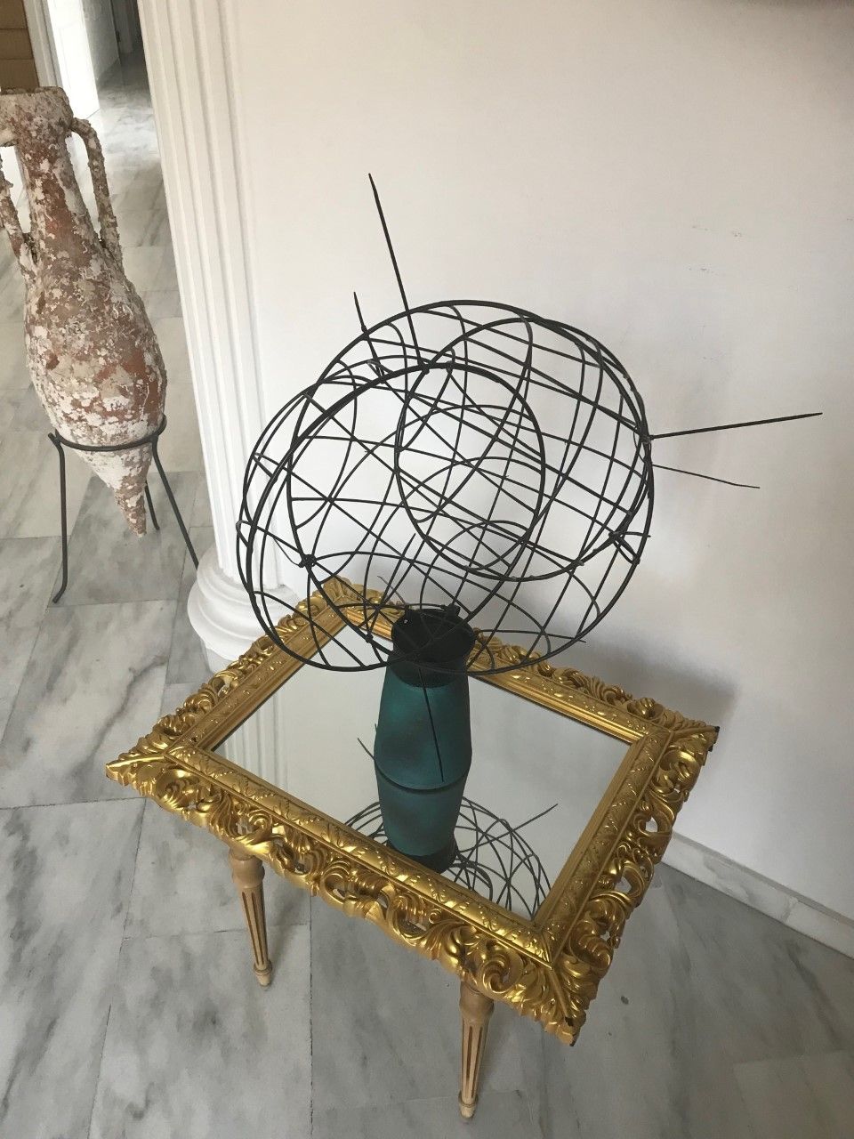 Eine Skulptur steht auf einem Tisch neben einem Bilderrahmen