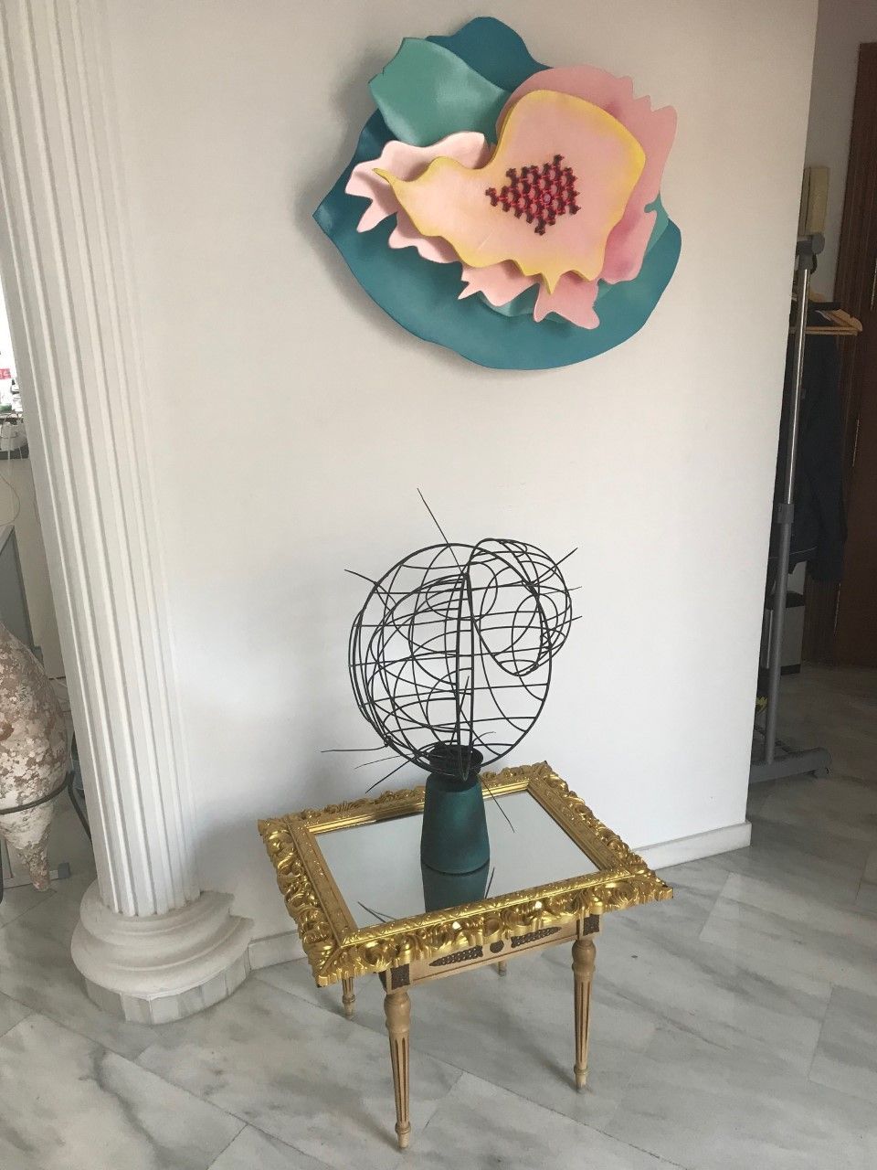 Ein Tisch mit einem Spiegel und einer Skulptur darauf