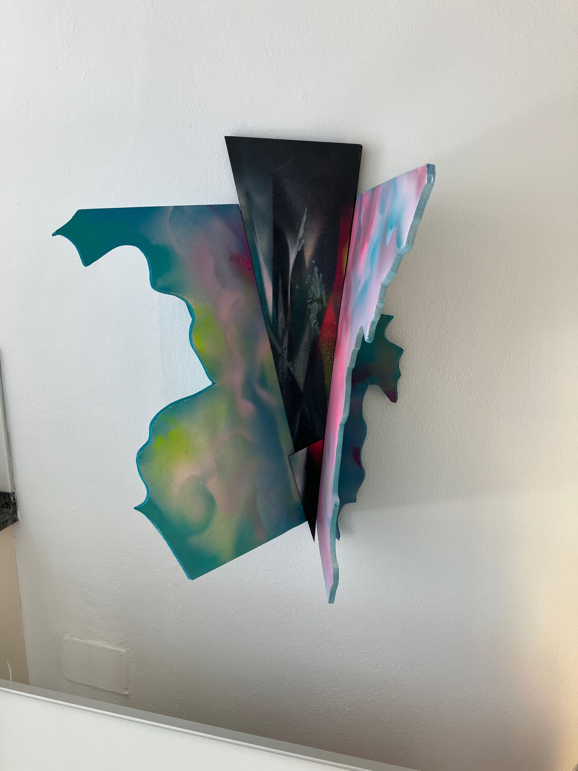 Ein buntes Gemälde hängt an einer weißen Wand