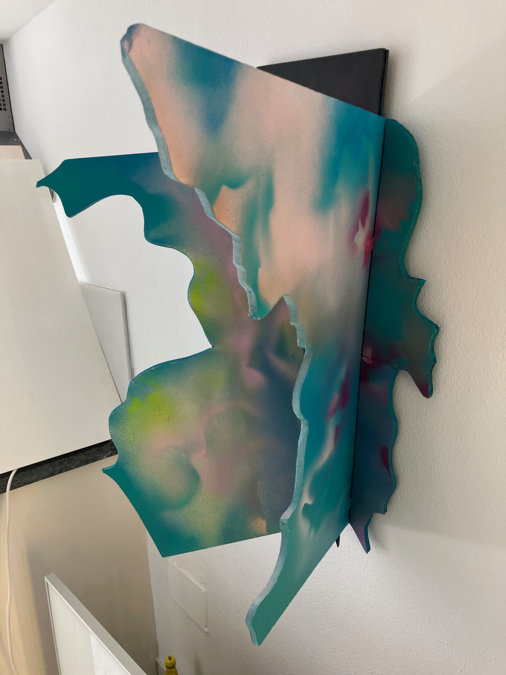 Ein blau-rosa Gemälde hängt an einer Wand