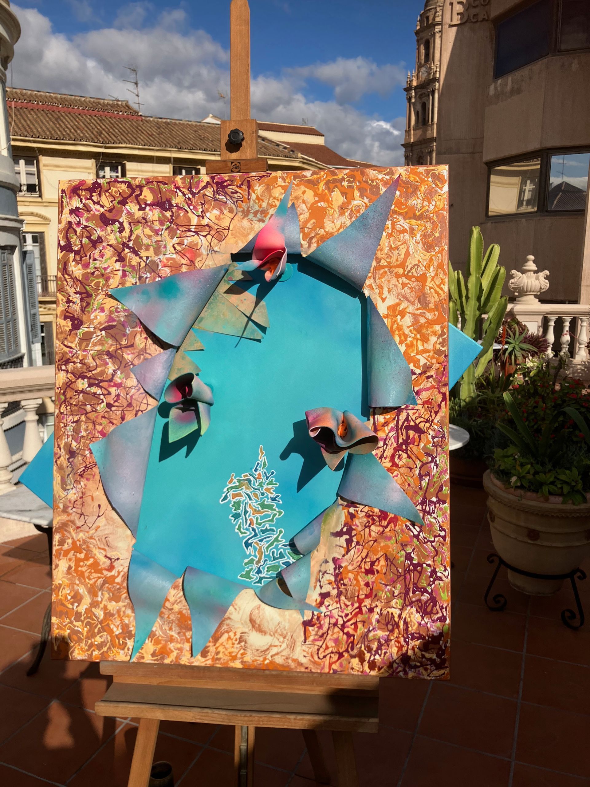 Ein Gemälde steht auf einer Staffelei auf einem Balkon