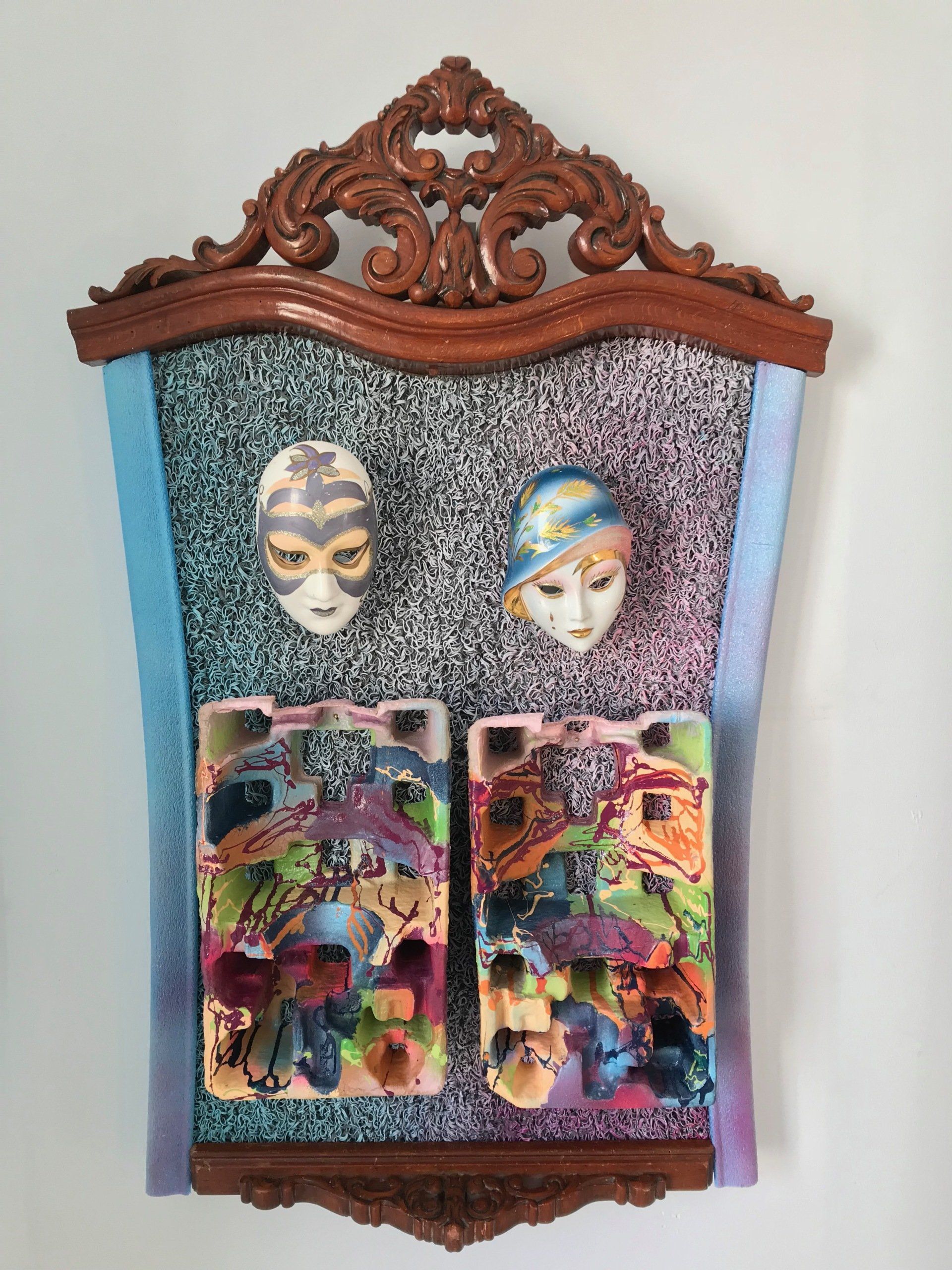 Ein Holzrahmen mit zwei Masken darauf
