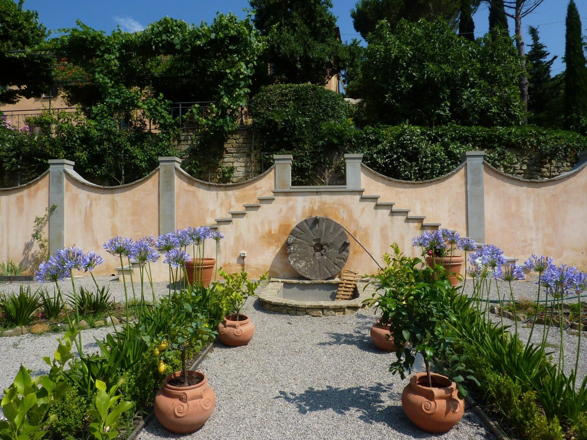 Ein Garten mit Topfpflanzen und einem Rad in der Mitte