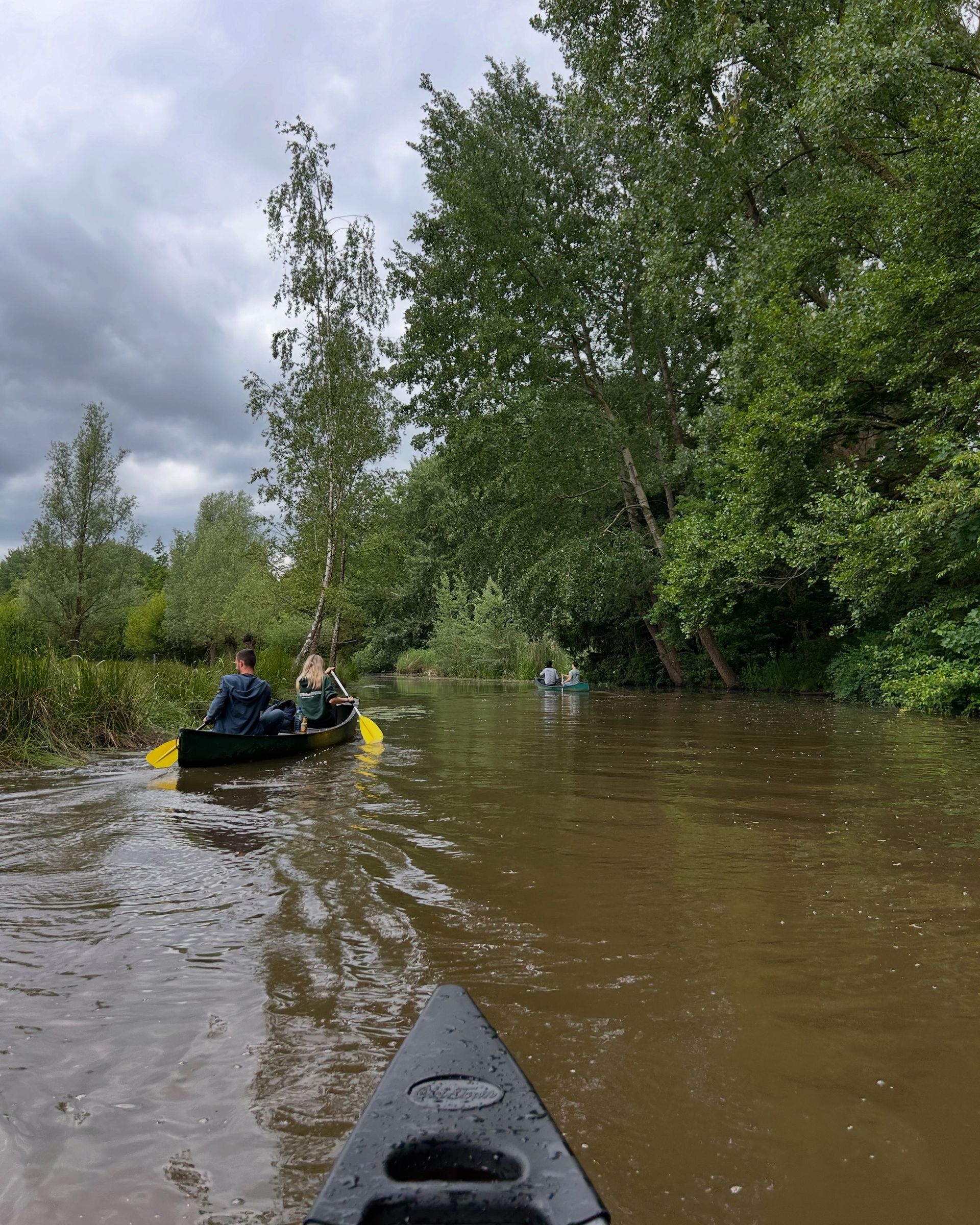 Een groep mensen vaart in een kajak over de rivier.