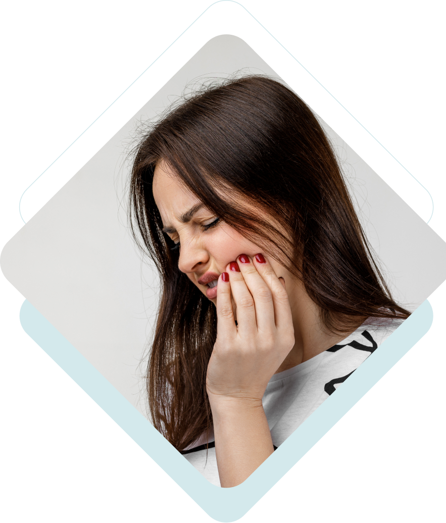 Woman with brown hair holding her jaw, indicating tooth pain.