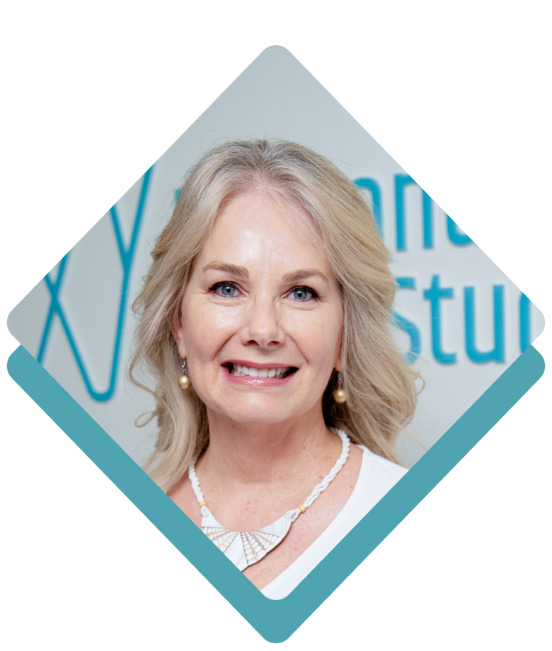 Woman with blonde hair, smiling in a teal diamond shape. Wearing a white top and necklace.
