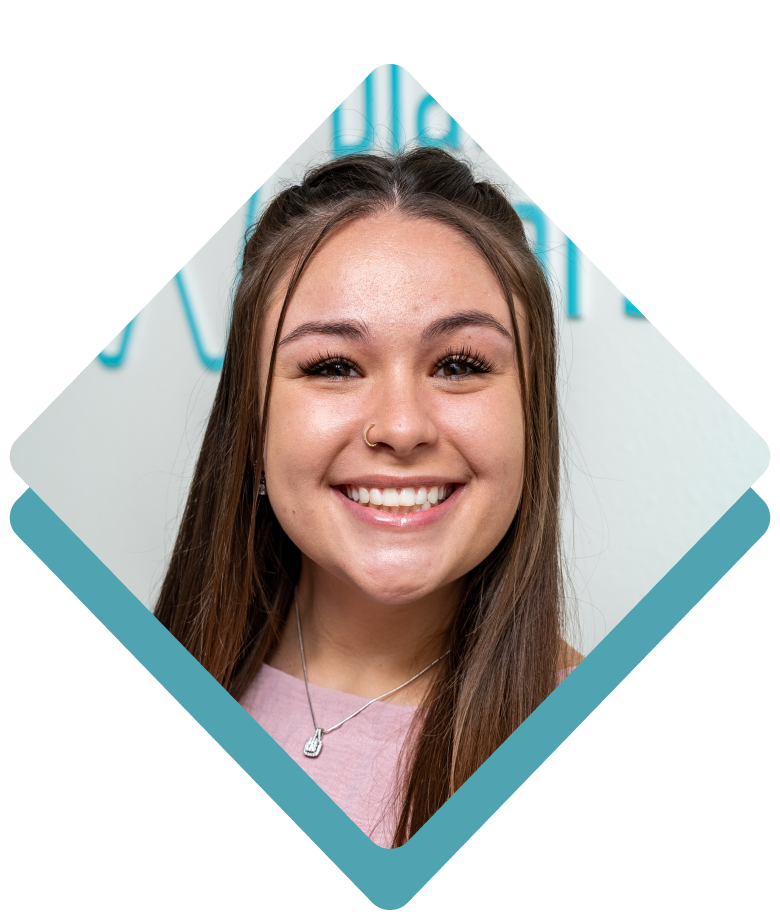 Smiling young woman in a pink shirt, framed in a blue diamond shape.