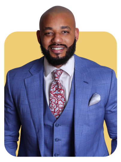 Man in blue suit with red patterned tie smiles, against a yellow backdrop.