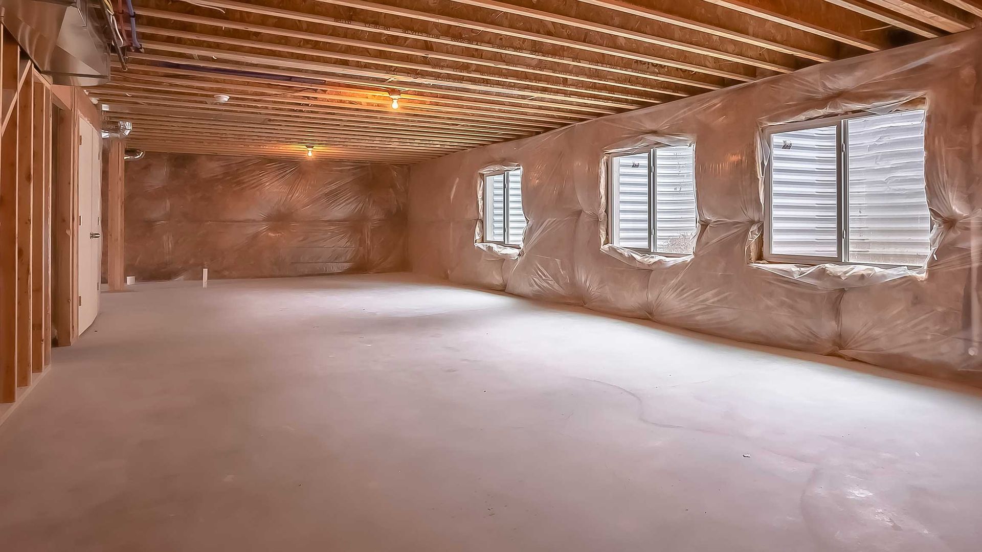 Unfinished basement with exposed beams, plastic walls, and three windows. Unfinished basement with exposed beams, plastic walls, and three windows.