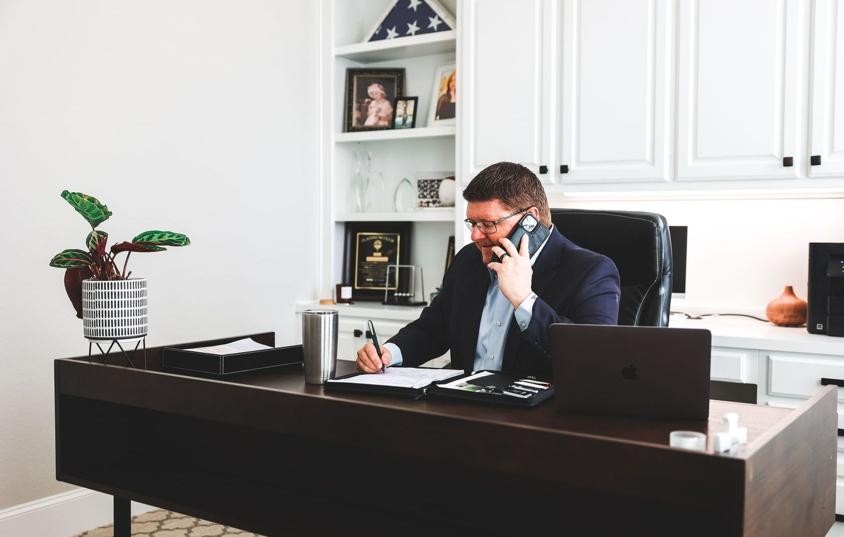 A man is giving a key to a woman who is signing a contract.