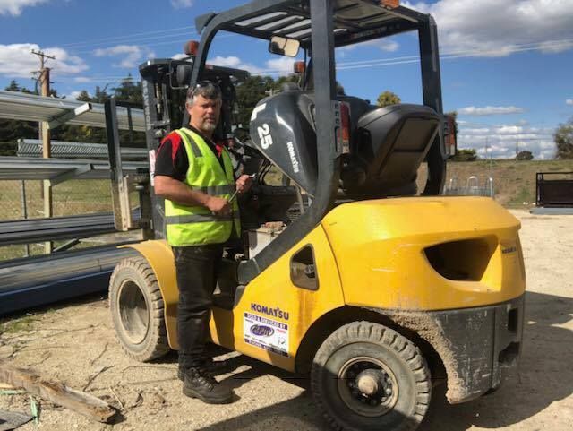Man in Safety Vest Beside Yellow Forklift — A1 Forklifts In Maclean, NSW
