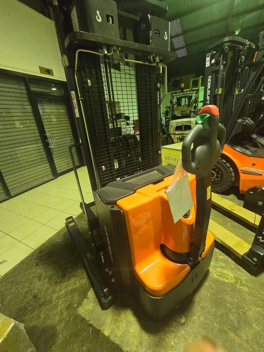Orange and Black Electric Stand-up Forklift in a Warehouse — A1 Forklifts In Kempsey, NSW