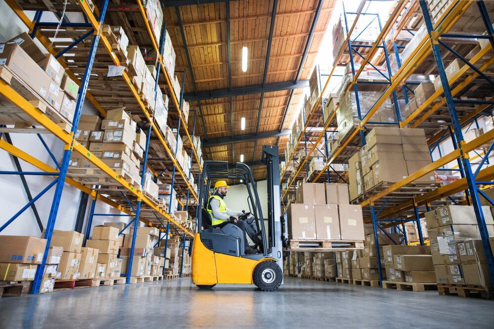 Forklift Operator in Yellow Safety Vest in a Warehouse — A1 Forklifts In Taree, NSW