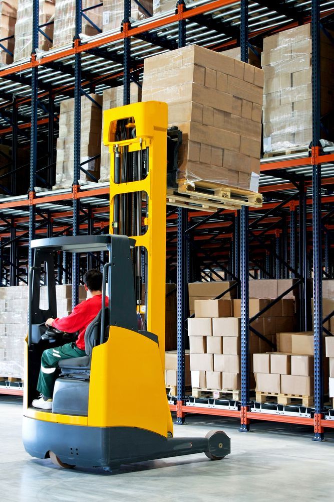 Forklift Operator in Yellow Vehicle Raising Pallet of Boxes — A1 Forklifts In Bellingen, NSW