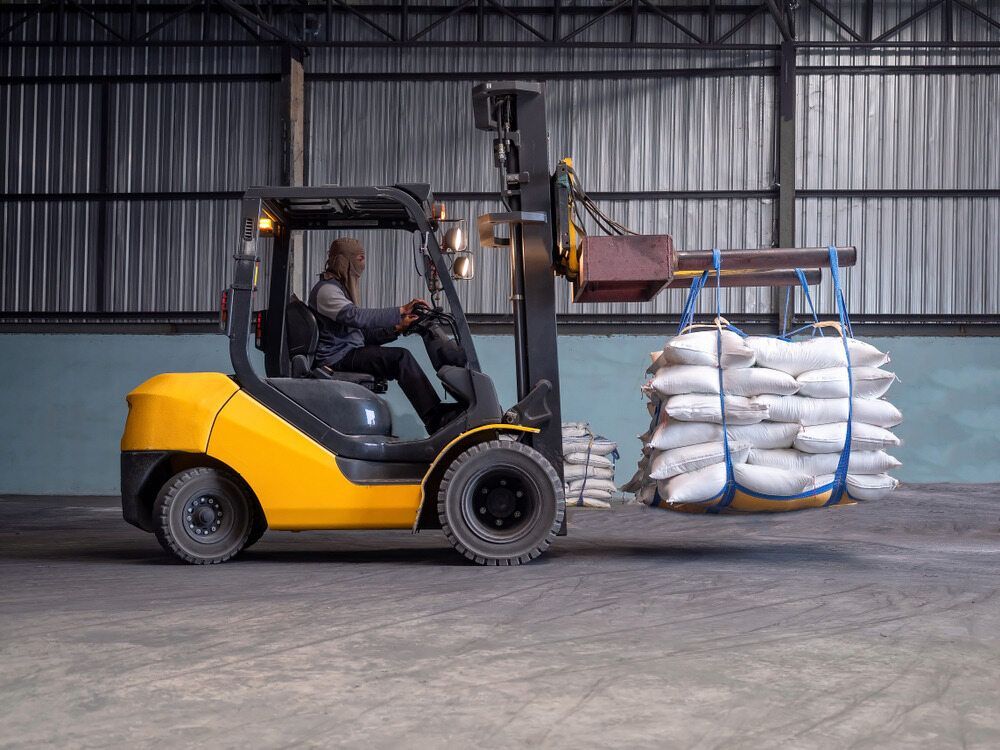 Yellow Forklift Carrying a Load of White Bags — A1 Forklifts In Taree, NSW
