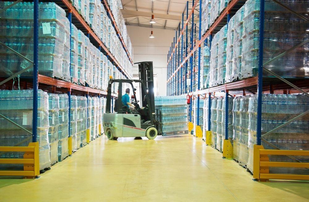 Forklift in a Warehouse Moving Pallets of Bottled Water — A1 Forklifts In Forster, NSW