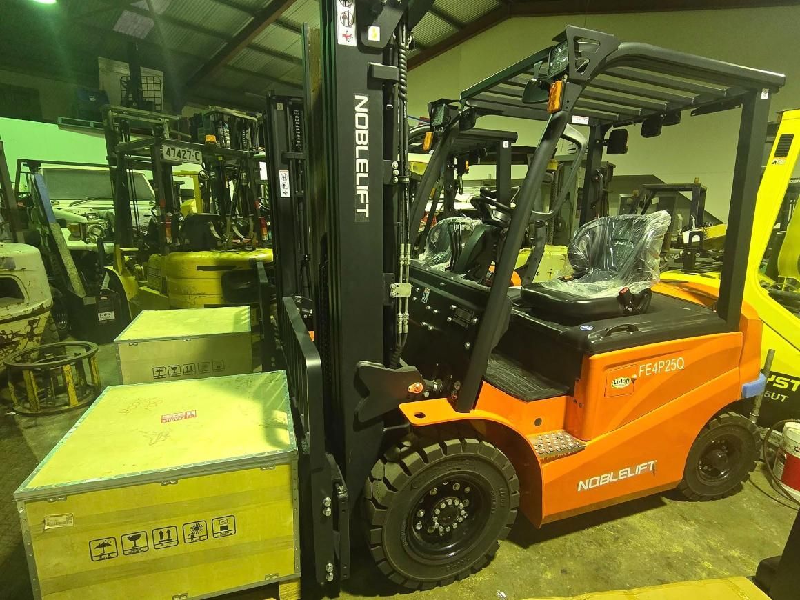 Orange Forklift Lifting a Wooden Crate in a Warehouse — A1 Forklifts In Kempsey, NSW