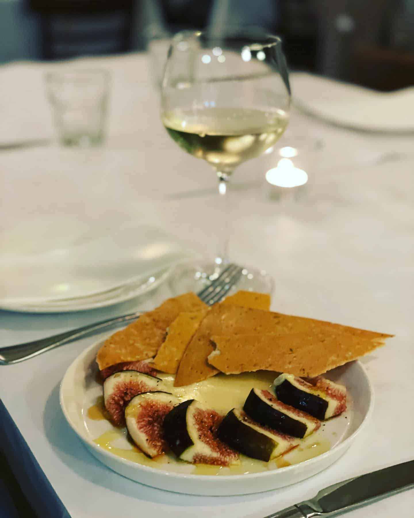 A Plate of Food and a Glass of Wine on a Table — Onesta Cucina in Bowral, NSW