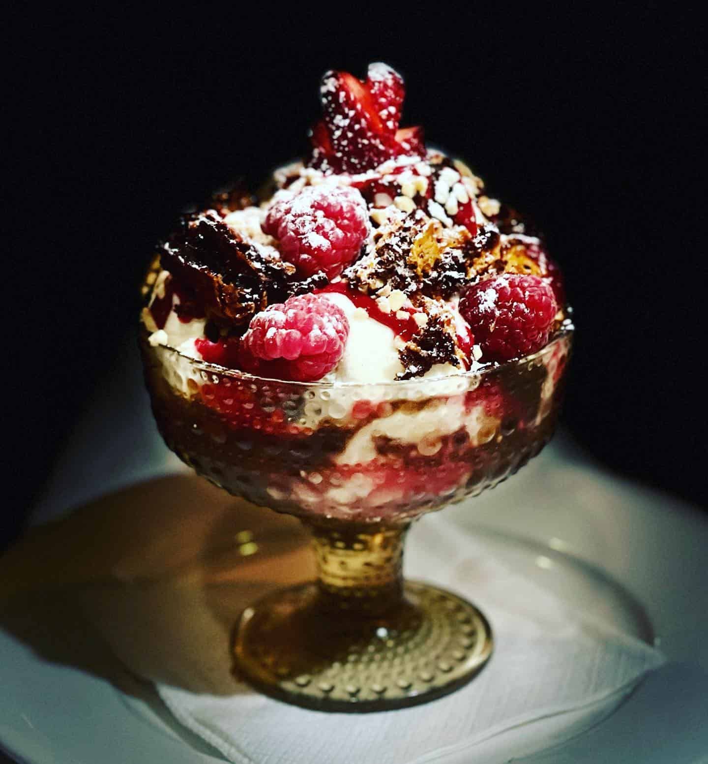 A Dessert in a Glass Bowl With Raspberries on Top — Onesta Cucina in Bowral, NSW