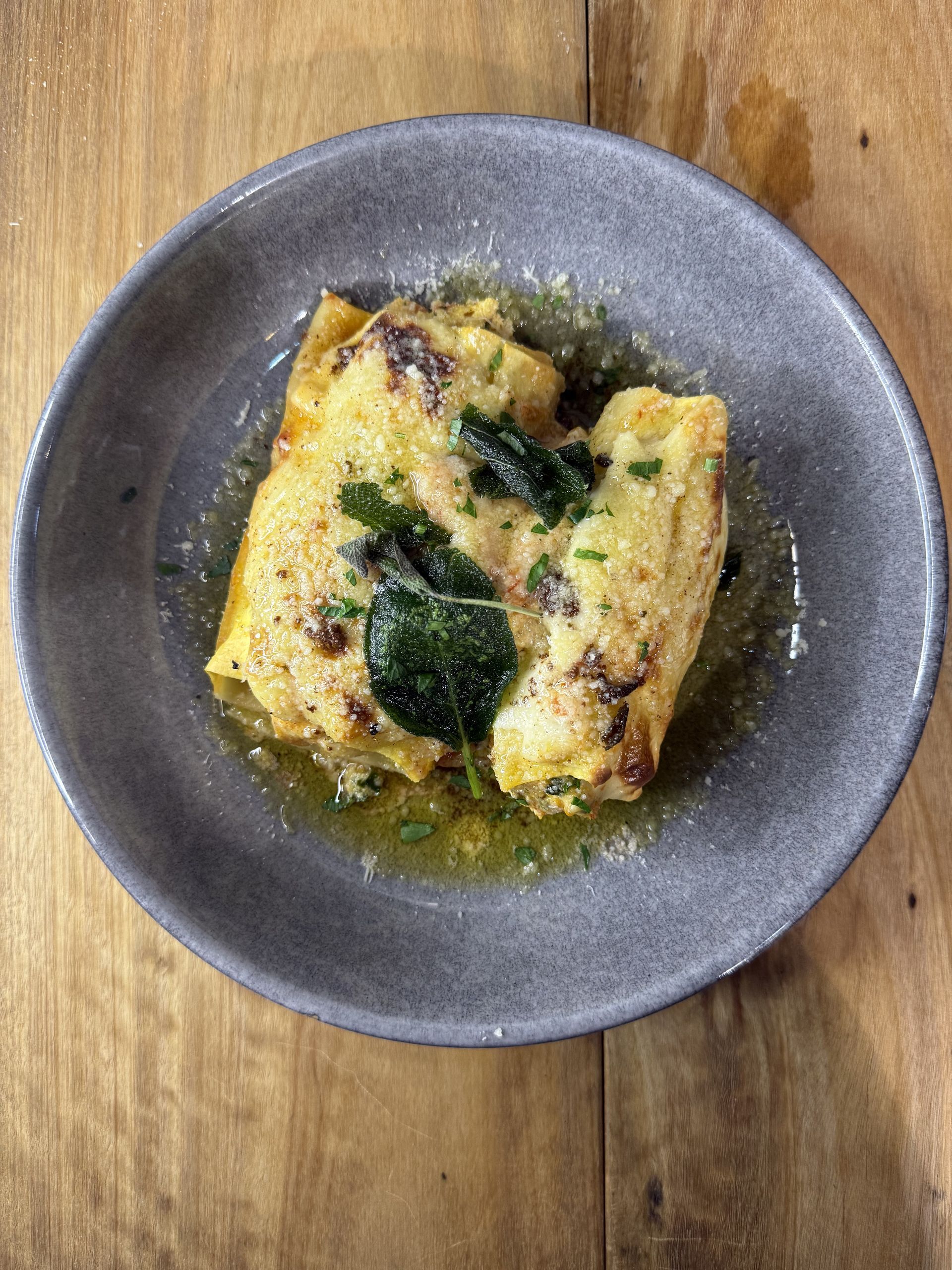 A grey plate with a creamy lasagne — Onesta Cucina in Bowral, NSW