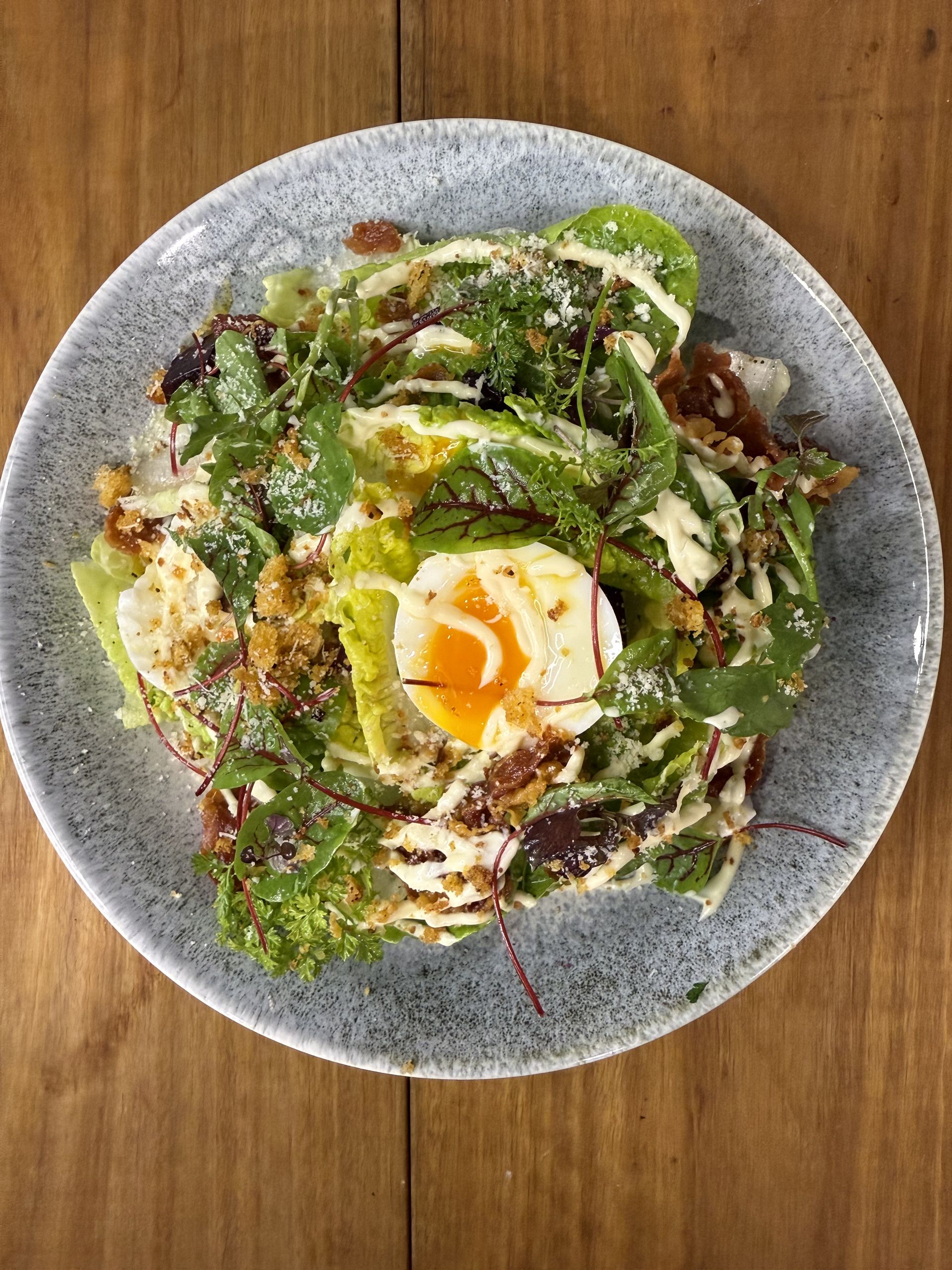 A plate on a table with a caesar salad — Onesta Cucina in Bowral, NSW