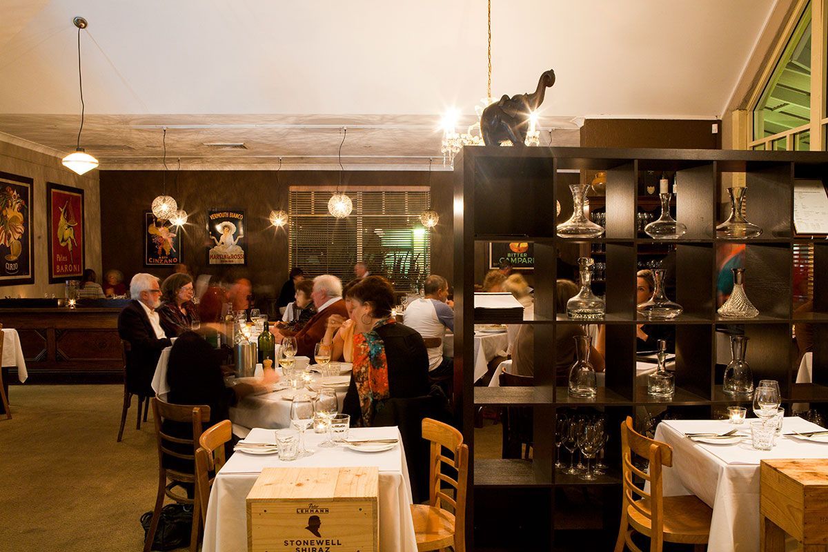 A Group of People Are Sitting at Tables in a Restaurant — Onesta Cucina in Bowral, NSW