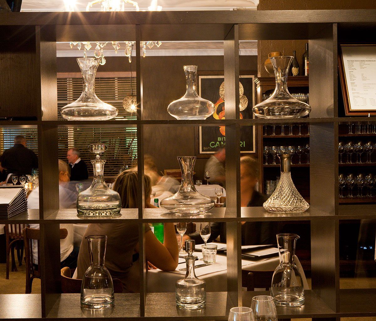 A Shelf Full of Bottles and Glasses in a Restaurant — Onesta Cucina in Bowral, NSW