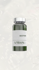 A bottle of biotin is sitting on a white surface.