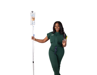 A woman in a green scrub suit is holding an iv bag from urbanrx helath lounge in houston, tx
