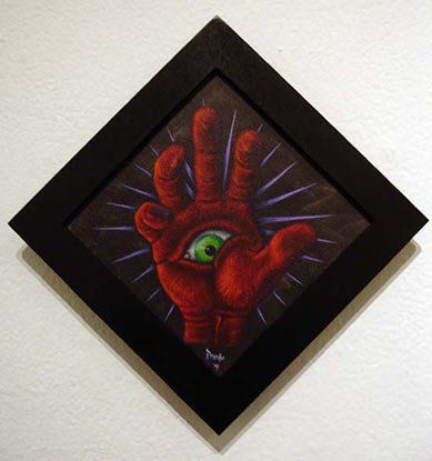 A framed painting of a hand with a green eye