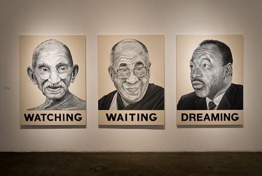 Three paintings of three men are hanging on a wall.