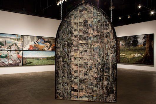 A room with paintings on the walls and a large sculpture in the middle of the room.