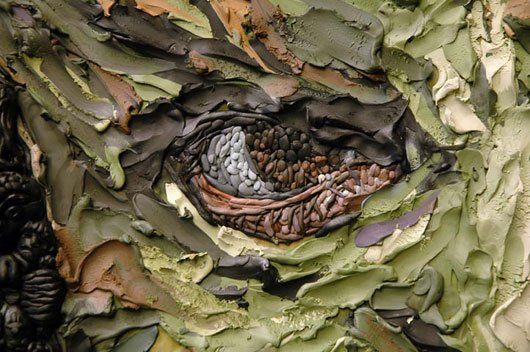 A close up of a painting of a person 's face made of leaves.