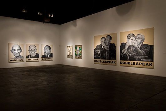 A room with a lot of paintings on the wall and a sign that says double speak