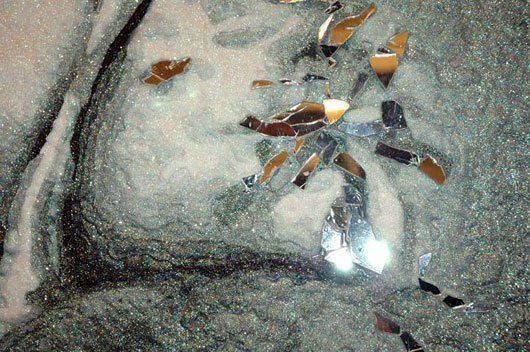 A close up of a broken mirror on a table.
