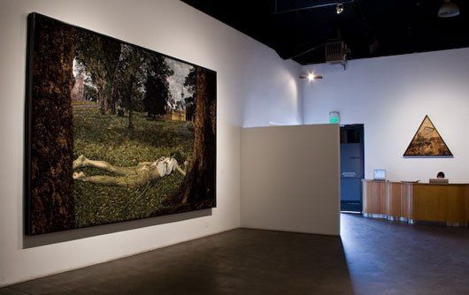 A large painting of a woman laying under a tree