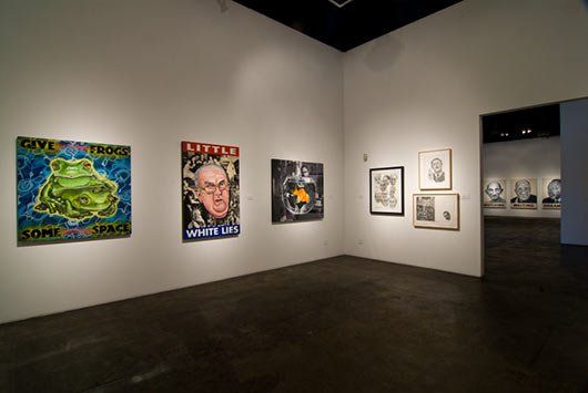 A room with a lot of paintings on the wall.