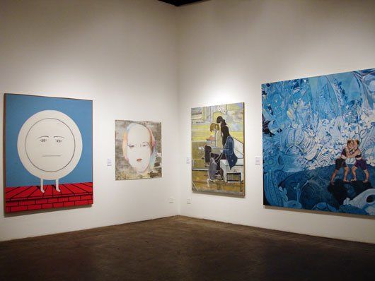 A room with a lot of paintings on the wall.