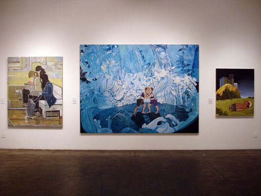 Three paintings are hanging on a wall in a museum.