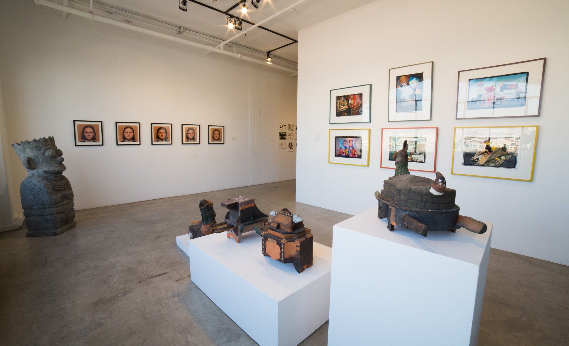 A room with a lot of sculptures and pictures on the wall