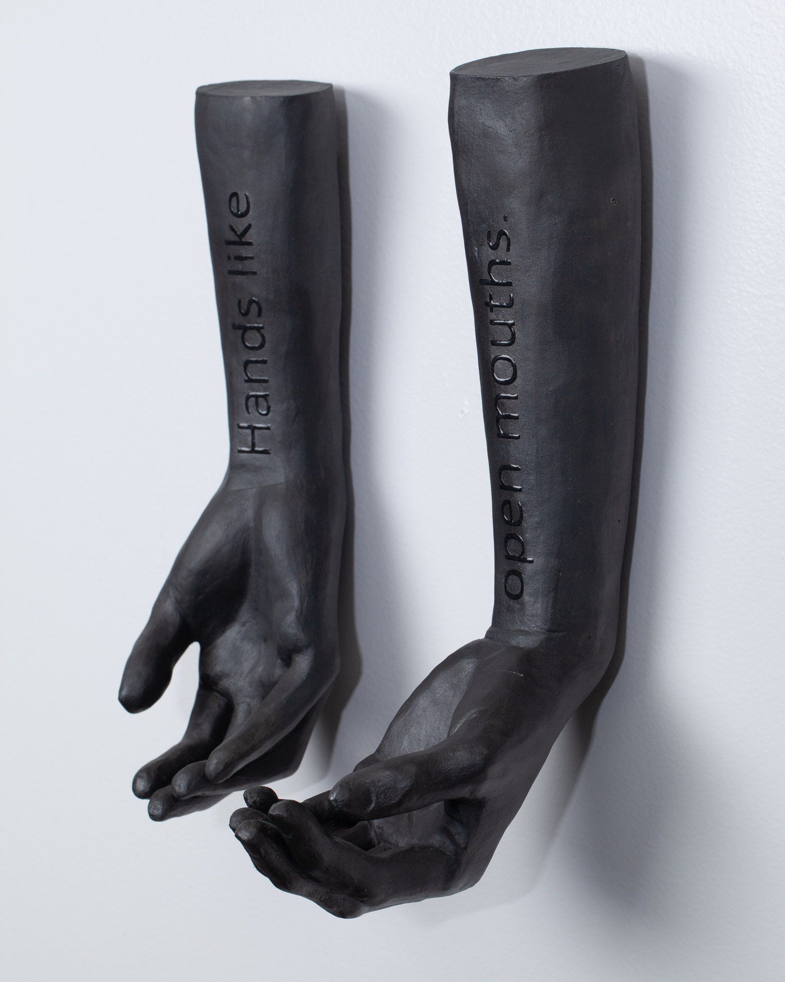 A pair of black hands that say hands like open mouths