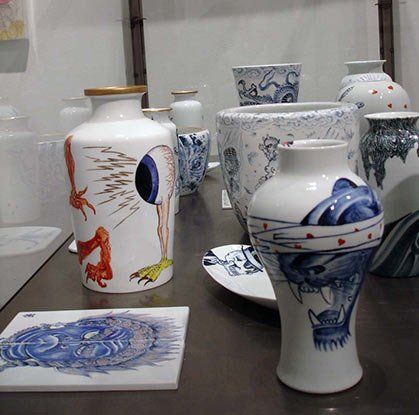 A bunch of vases on a table including one with a dragon on it