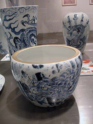 A blue and white vase with a dragon on it is sitting on a table.